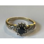 A 9 CARAT GOLD RING WITH A CENTRE SAPPHIRE SURROUNDED BY DIAMONDS SIZE O