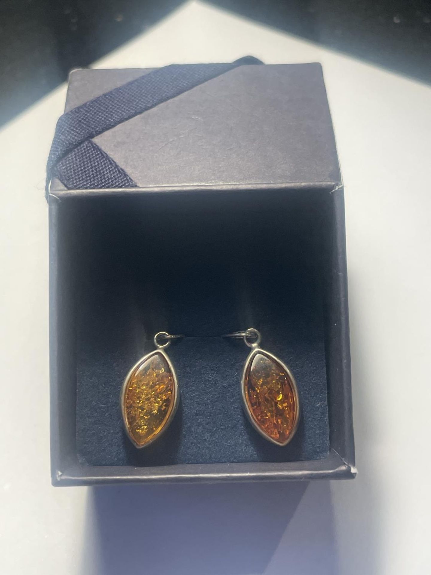 A PAIR OF SILVER AND AMBER DROP EARRINGS IN A PRESENTATION BOX