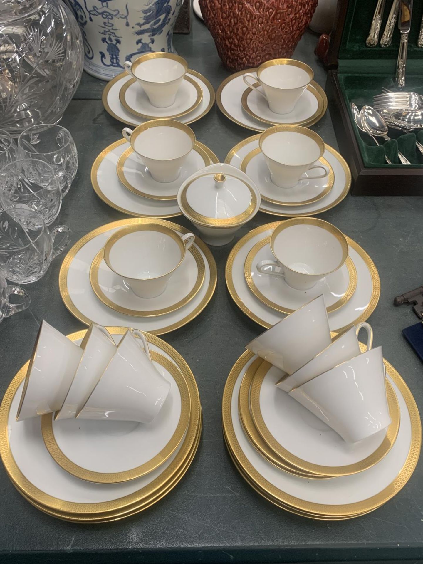 A CHINA PART TEASET IN WHITE WITH GILD TO THE RIMS TO INCLUDE A SUGAR BOWL, CUPS, SAUCERS AND SIDE