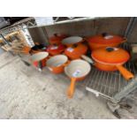 A LARGE COLLECTION OF ORANGE LE CREUSET PANS TO INCLUDE CASAROLE DISHES, VARIOUS SIZED SAUCEPANS AND