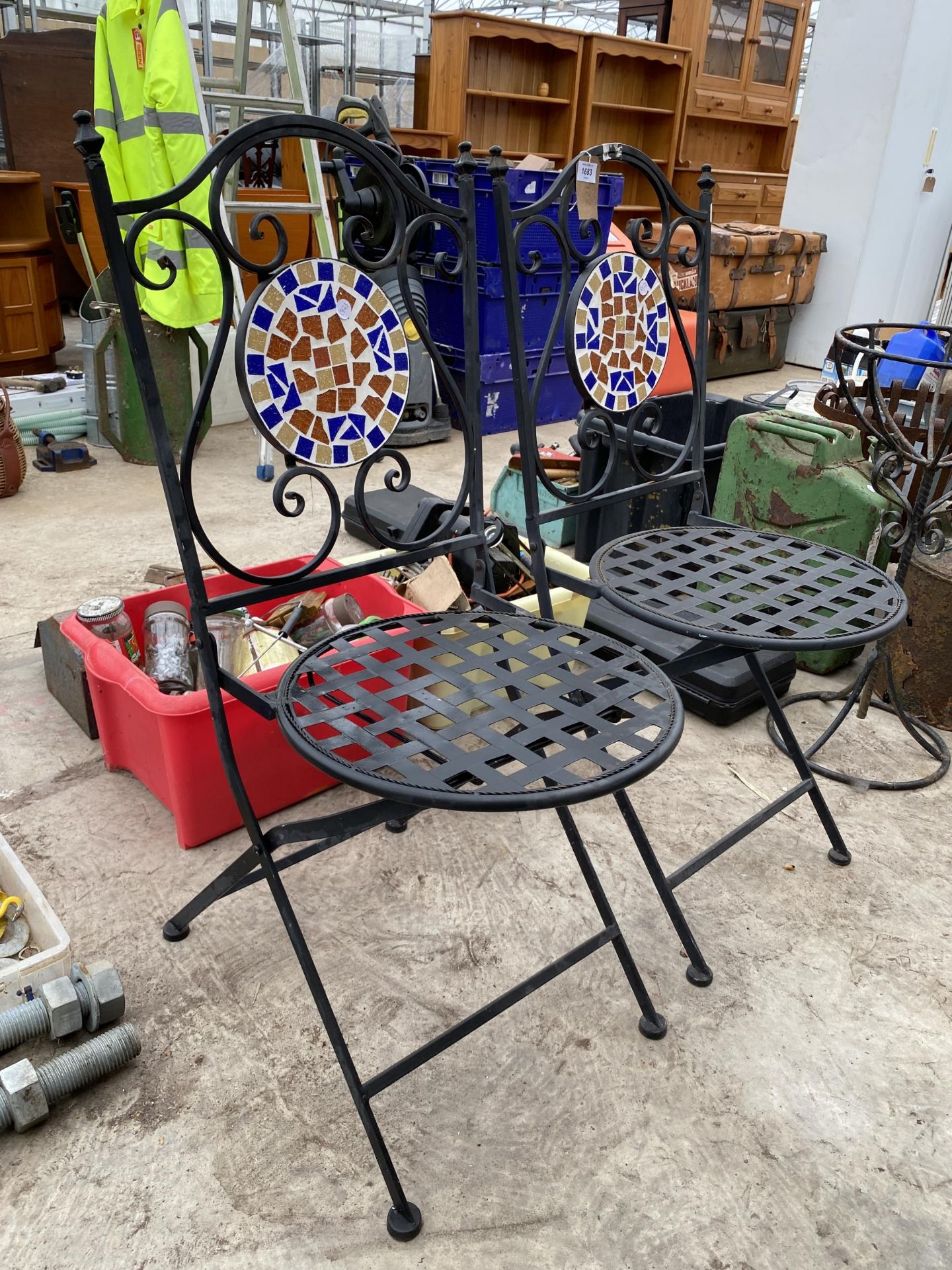 A PAIR OF METAL FOLDING BISTRO CHAIRS WITH TILED BACKS