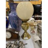 A VINTAGE BRASS OIL LAMP WITH A GLASS SHADE