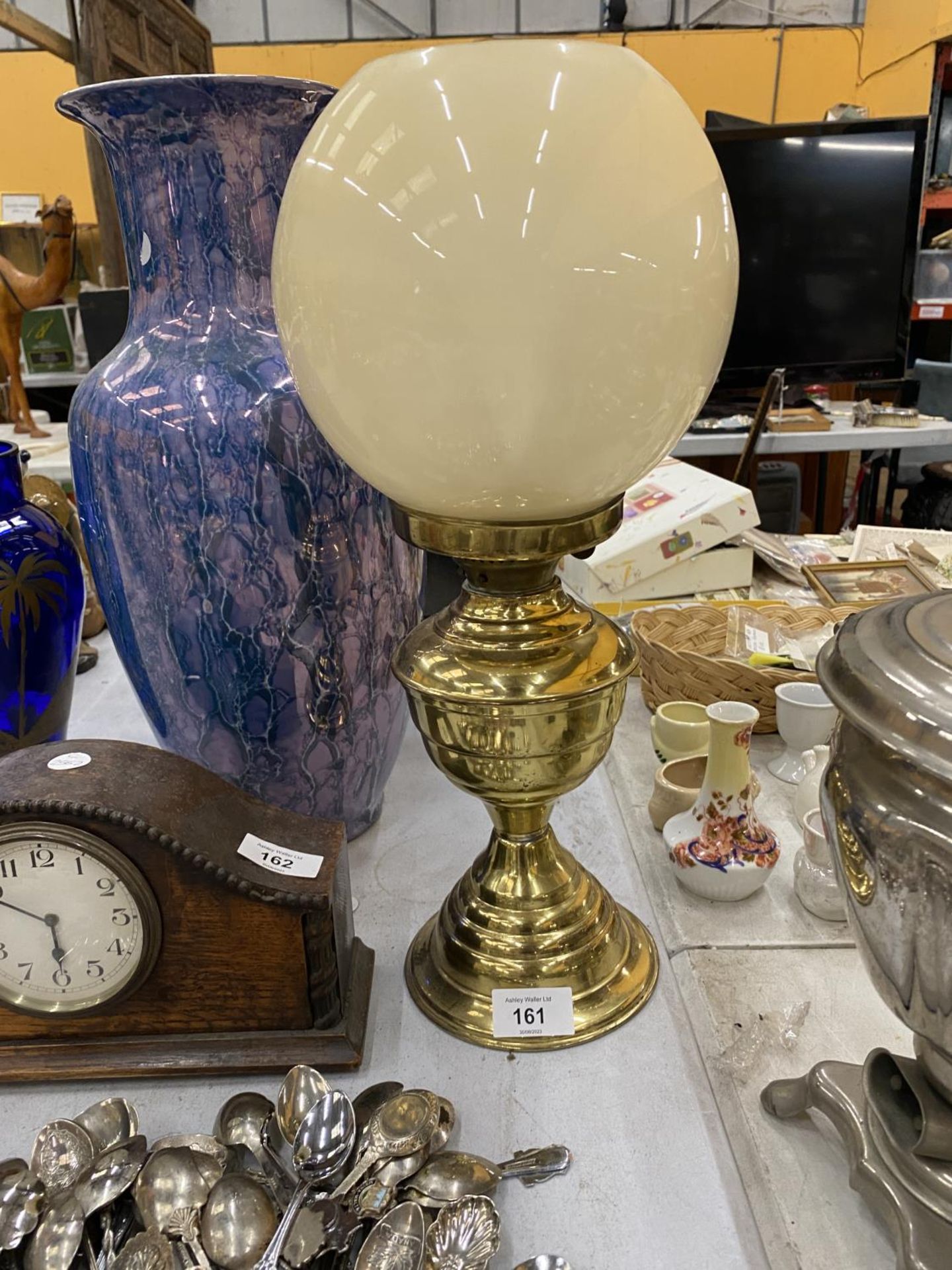 A VINTAGE BRASS OIL LAMP WITH A GLASS SHADE