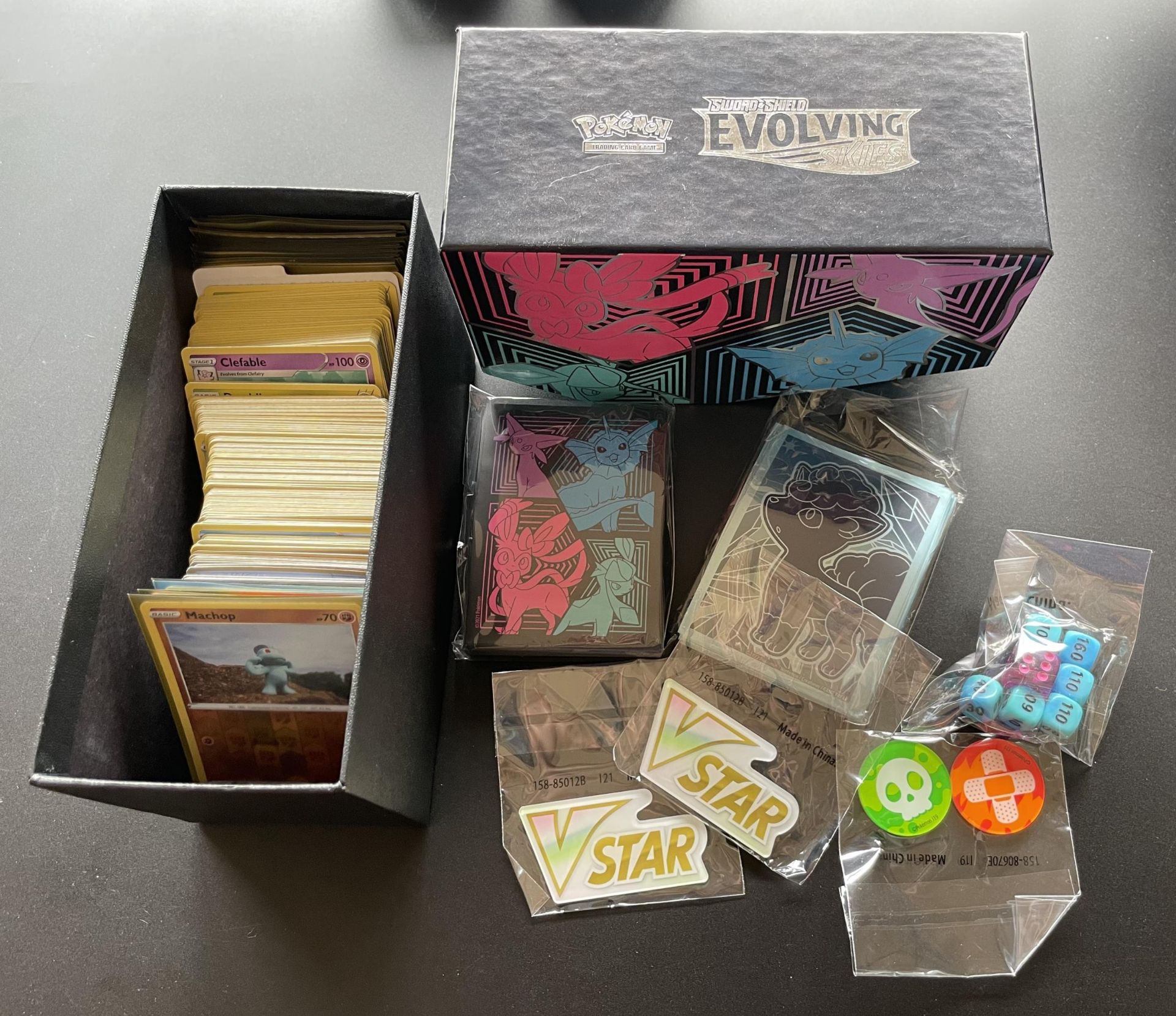 A TRAINER BOX OF ASSORTED POKEMON CARDS, GAME TOKENS, HOLOS ETC