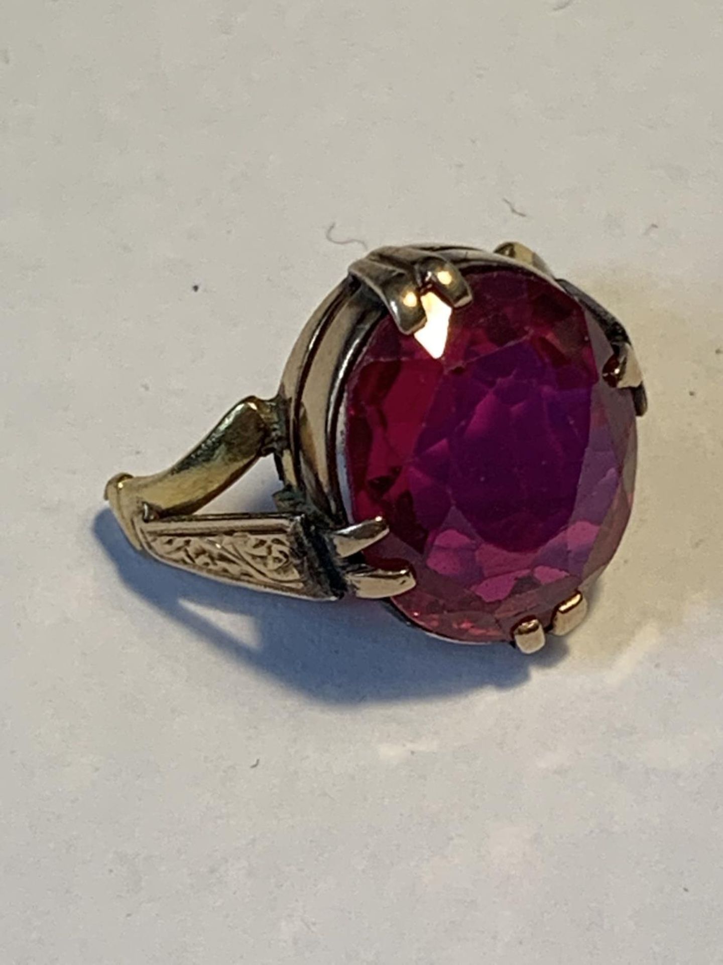 A TESTED TO 9 CARAT GOLD PART RING WITH RED STONE