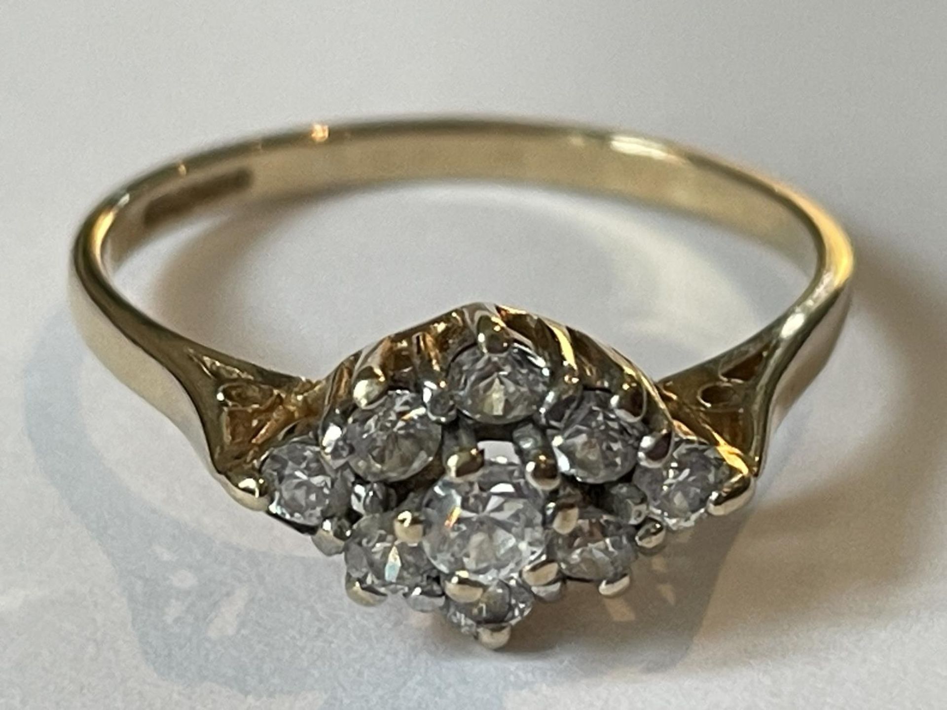 A 9 CARAT GOLD RING WITH NINE CUBIC ZIRCONIAS IN A DIAMOND PATTERN SIZE P