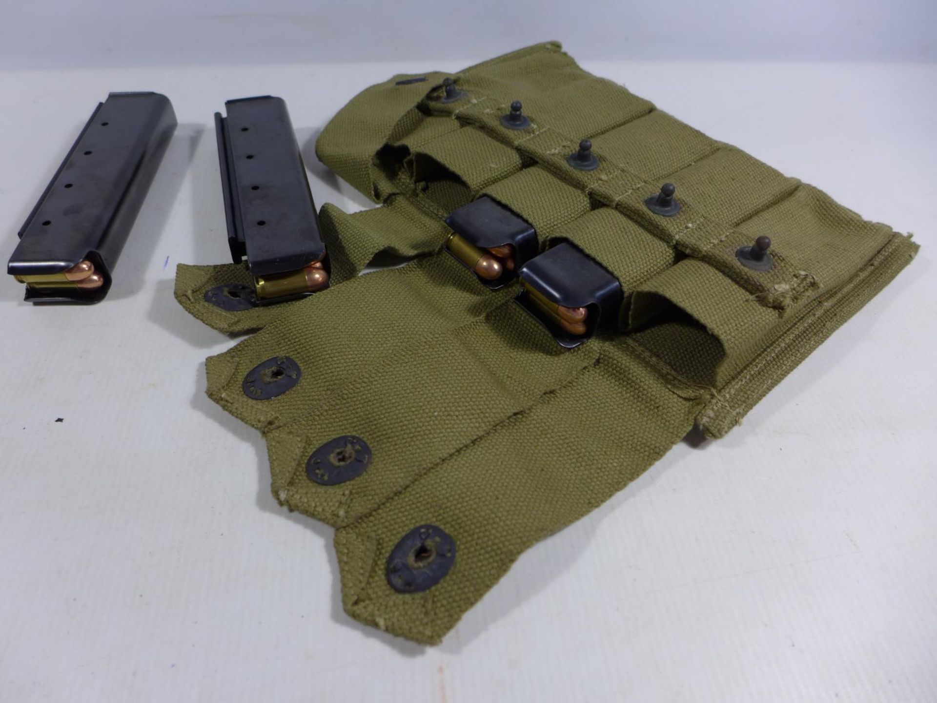 AN UNITED STATES MID 20TH CENTURY MILITARY CANVAS MAGAZINE POUCH WITH FOUR MAGAZINES WITH TEN