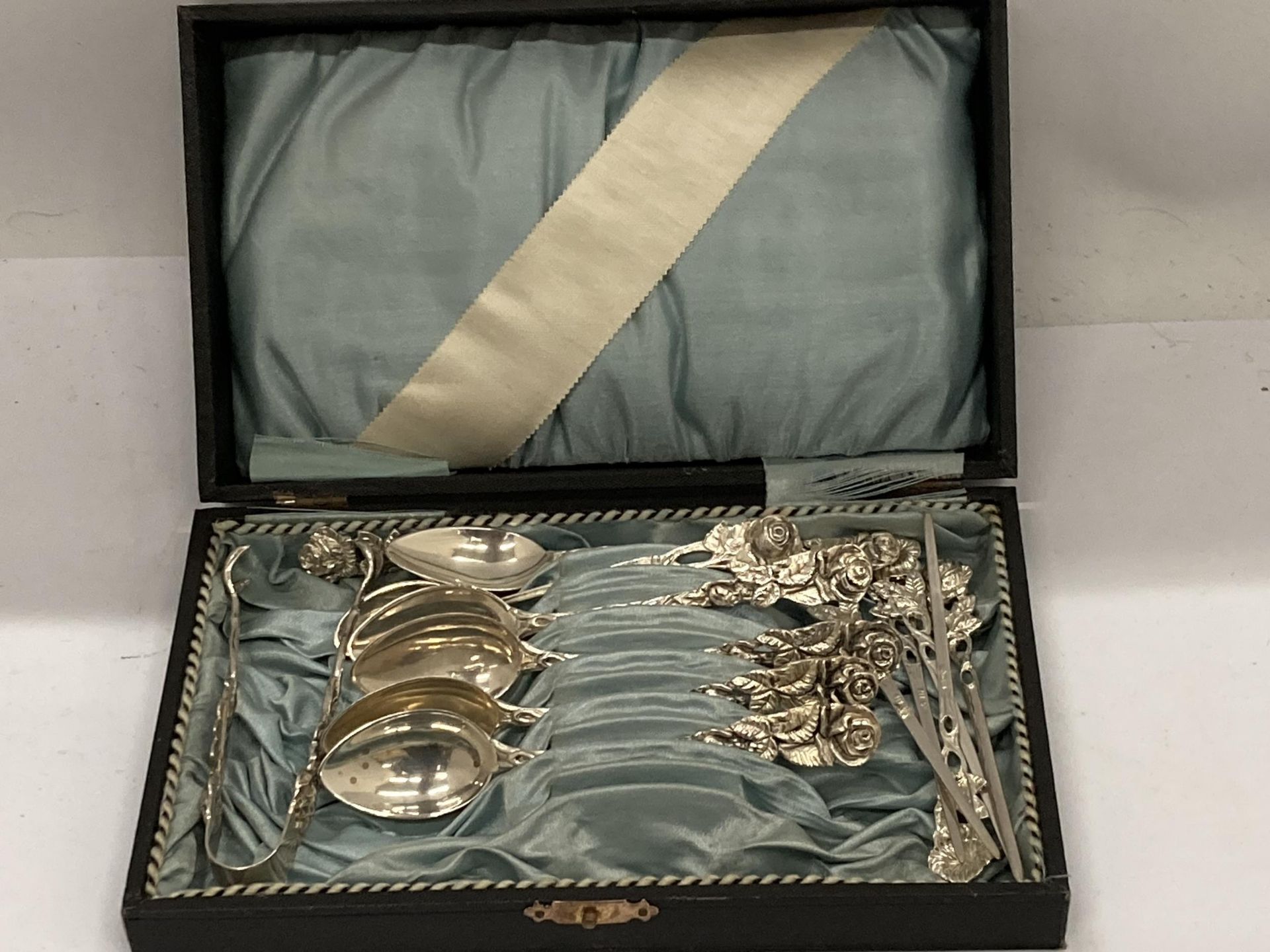 A CASED SET OF 800 GRADE CONTINENTAL SILVER TEASPOONS WITH MATCHING TONGS AND STICKS WITH FLORAL