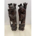 A PAIR OF CARVED HARDWOOD ORIENTAL FIGURES, HEIGHT 34CM