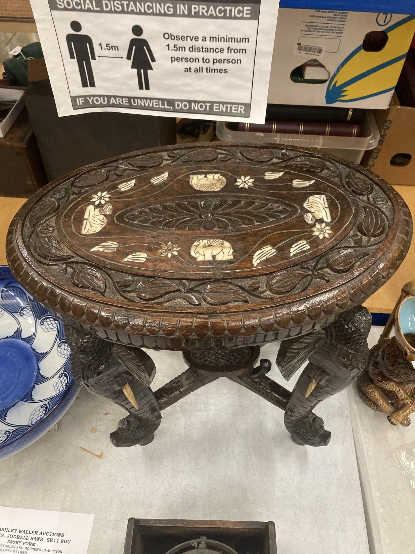 AN ORIENTAL CARVED HARDWOOD TABLE WITH ELEPHANT DESIGN LEGS