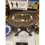 AN ORIENTAL CARVED HARDWOOD TABLE WITH ELEPHANT DESIGN LEGS