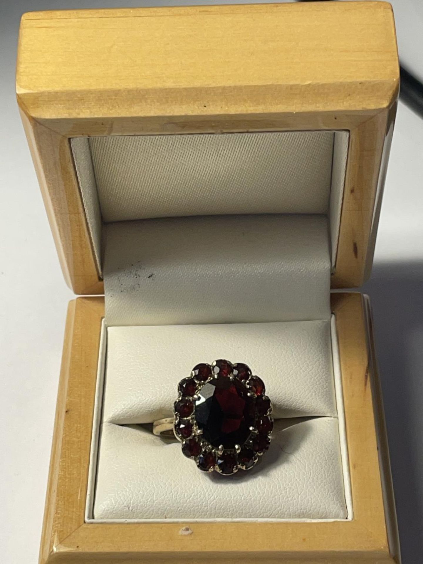 A 9CT YELLOW GOLD AND GARNET RING IN A FLOWER DESIGN SIZE P, WEIGHT 5.46 GRAMS