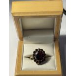 A 9CT YELLOW GOLD AND GARNET RING IN A FLOWER DESIGN SIZE P, WEIGHT 5.46 GRAMS