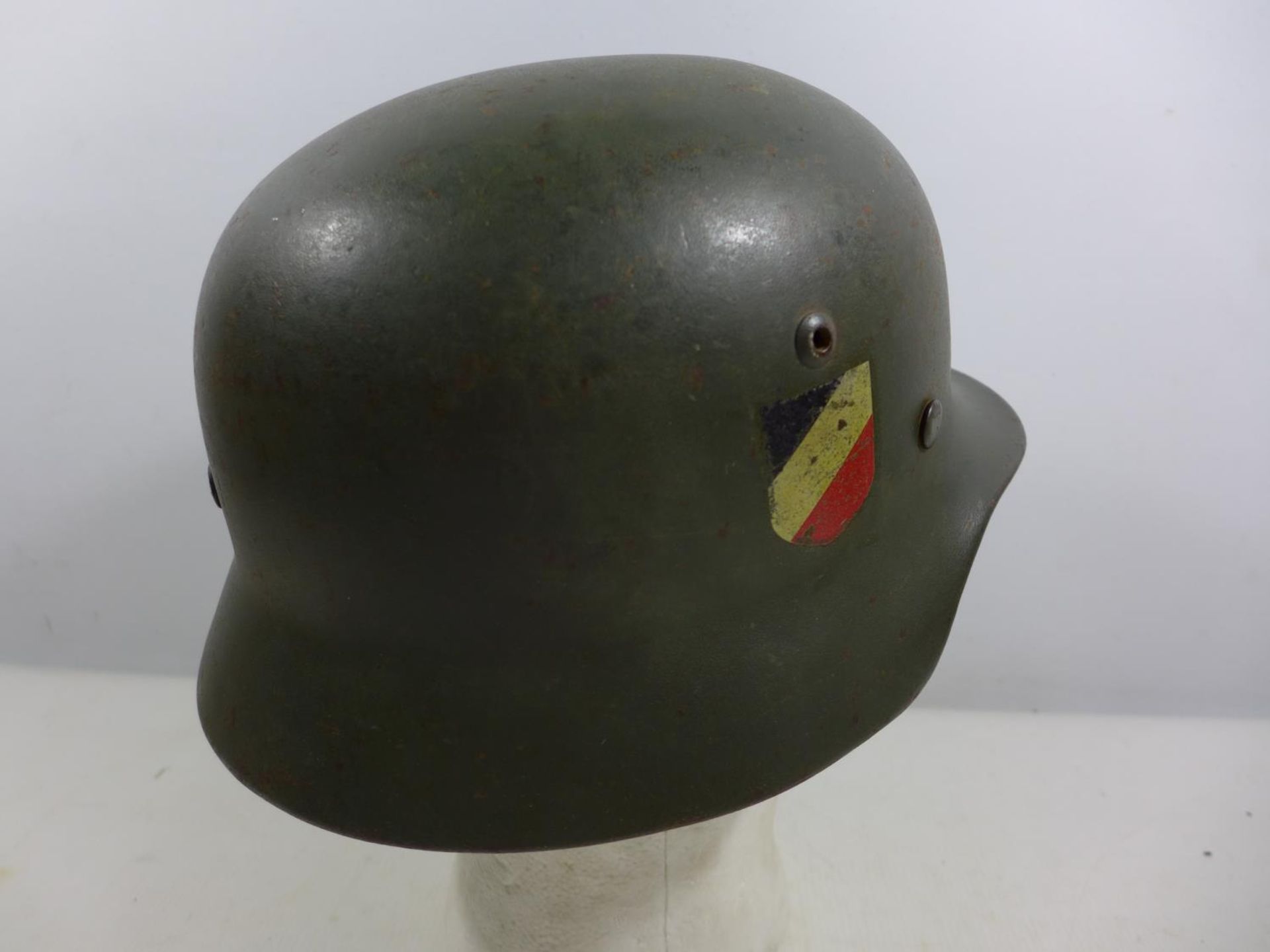 A GERMAN GREEN PAINTED METAL HELMET WITH EAGLE AND SWASTIKA DECORATION AND LEATHER LINING - Image 2 of 5