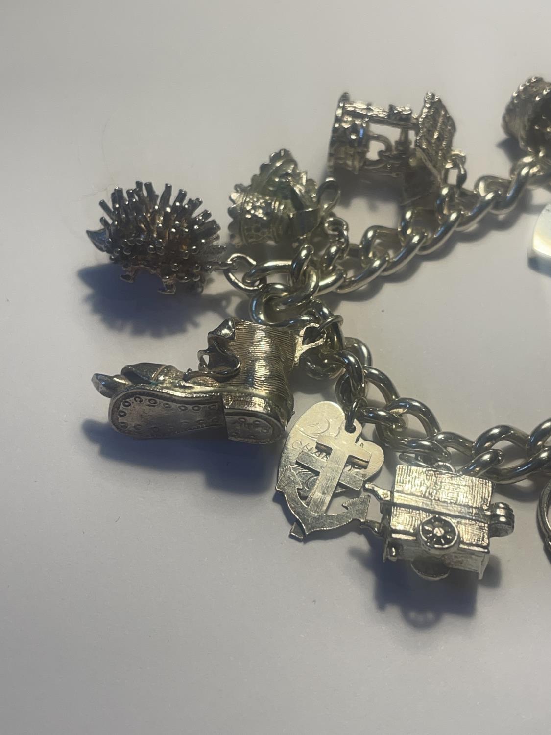 A SILVER CHARM BRACELET WITH ELEVEN CHARMS AND A HEART LOCK - Image 2 of 4