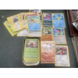 A POKEMON TIN WITH CARDS TO INCLUDE HOLOS, ETC