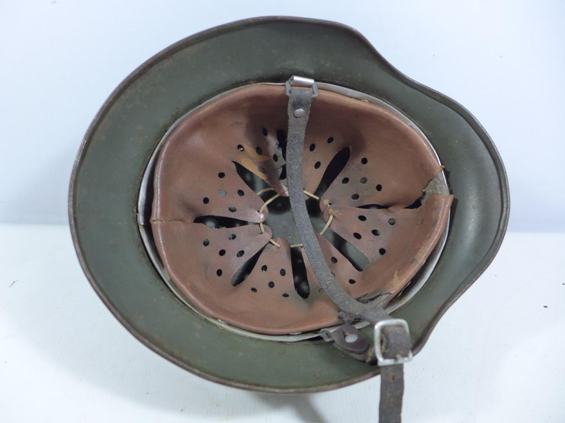 A GERMAN GREEN PAINTED METAL HELMET WITH EAGLE AND SWASTIKA DECORATION AND LEATHER LINING - Image 3 of 5