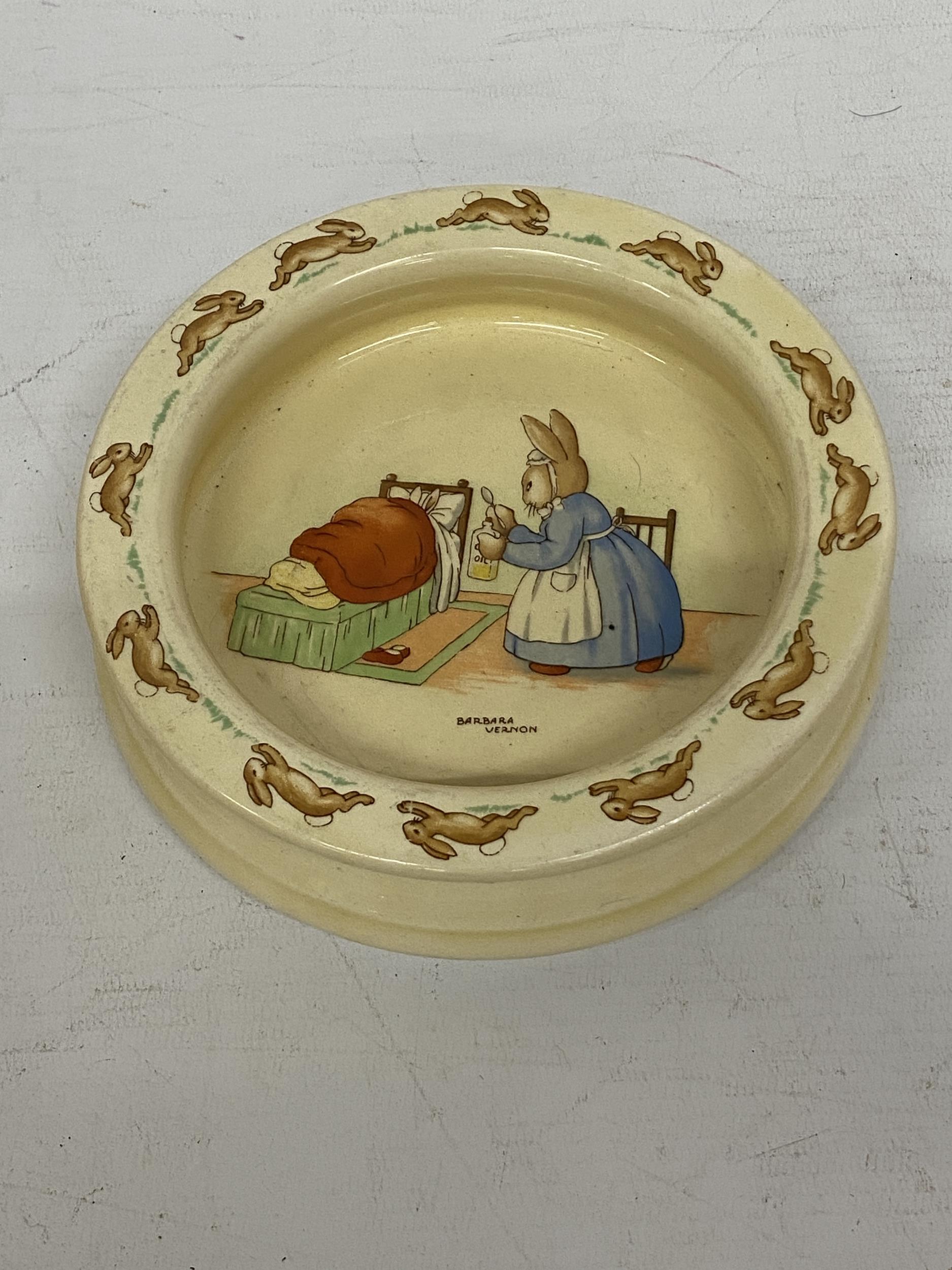 A ROYAL DOULTON BUNNYKINS DEEP IVORY GLAZED EARTHENWARE BABY PLATE "MEDICINE TIME" PRODUCED UNTIL