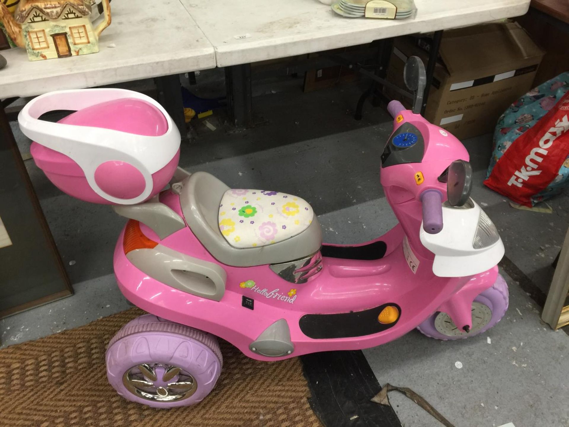 A CHILDREN'S PINK ELECTRIC THREE WHEELED SCOOTER WITH CHARGER - VENDOR STATES IN WORKING ORDER AND