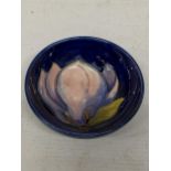 A MOORCROFT PINK MAGNOLIA PATTERN SMALL BOWL ON BLUE GROUND
