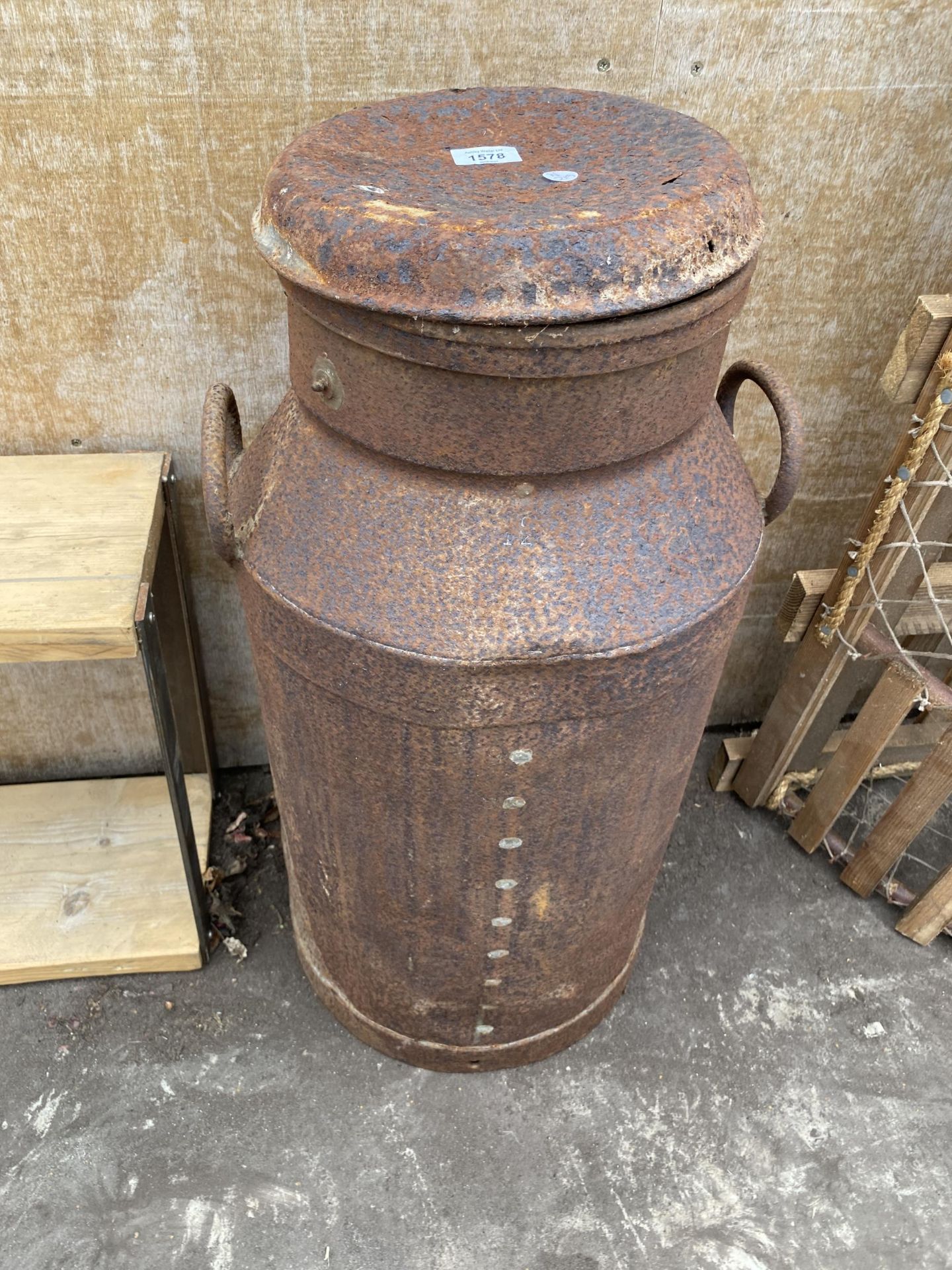 A VINTAGE MILK CHURN WITH LID BEARING AN INDISTINCT NAME