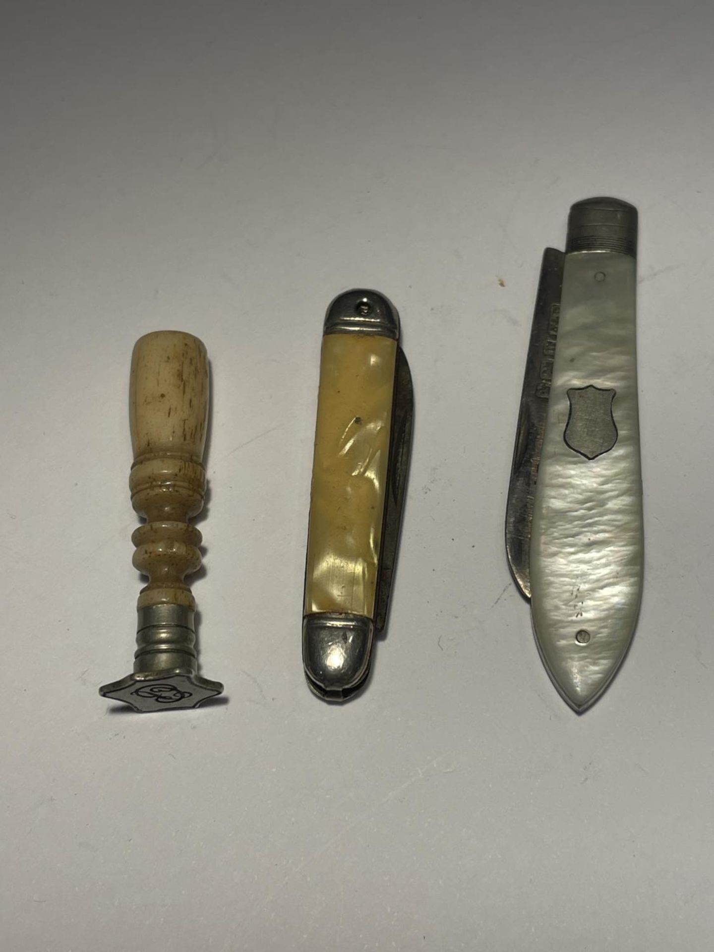 TWO PEN KNIVES ONE MOTHER OF PEARL AND HALLMARKED SHEFFIELD SILVER AND A BONE SEAL