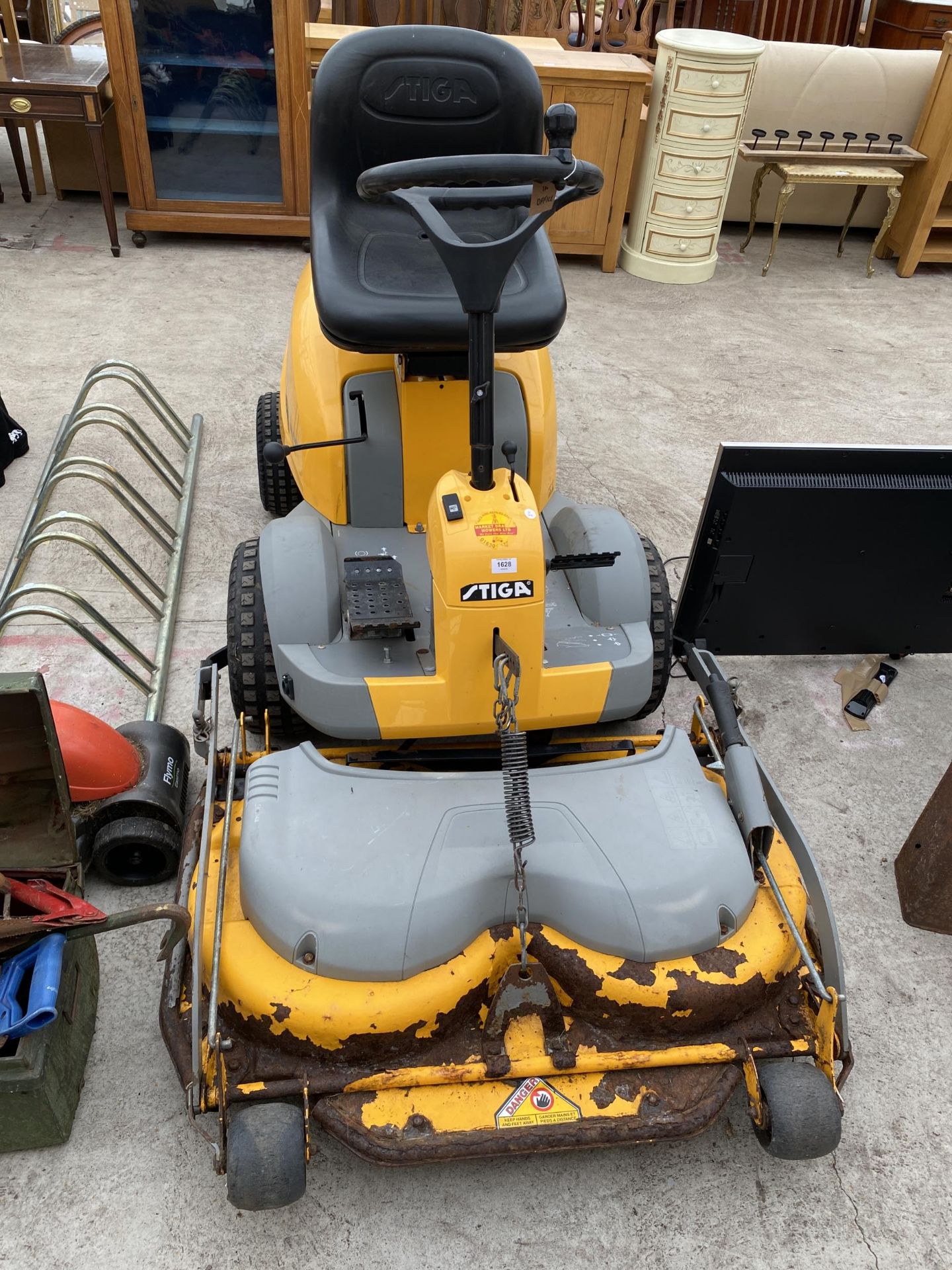 A STIGA RIDE ON LAWN MOWER WITH FRONT DECK AND KEY IN THE OFFICE