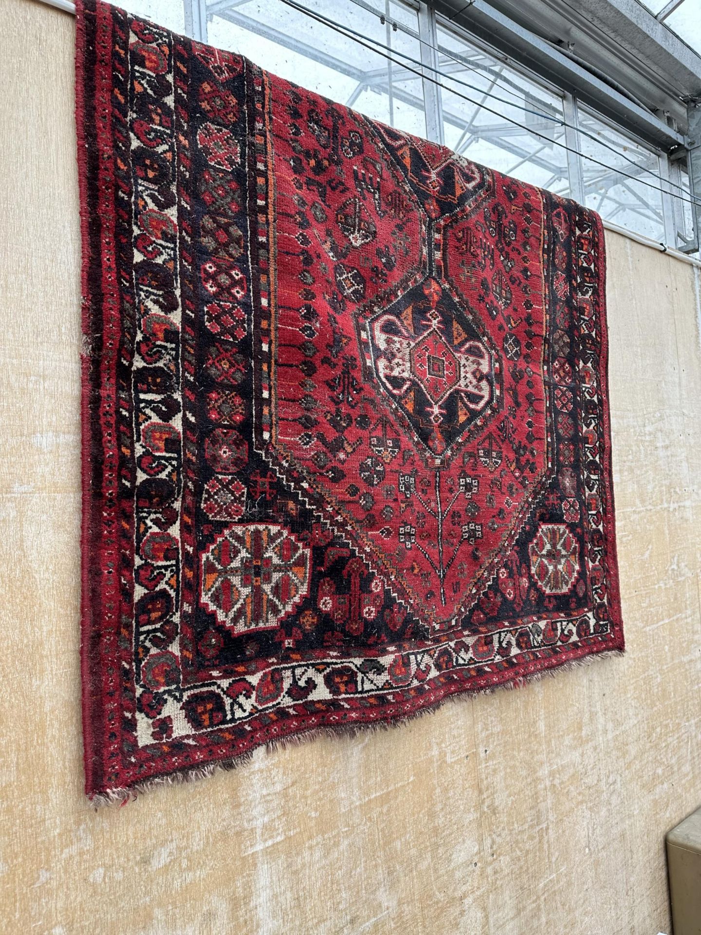 A RED PATTERNED FRINGED RUG