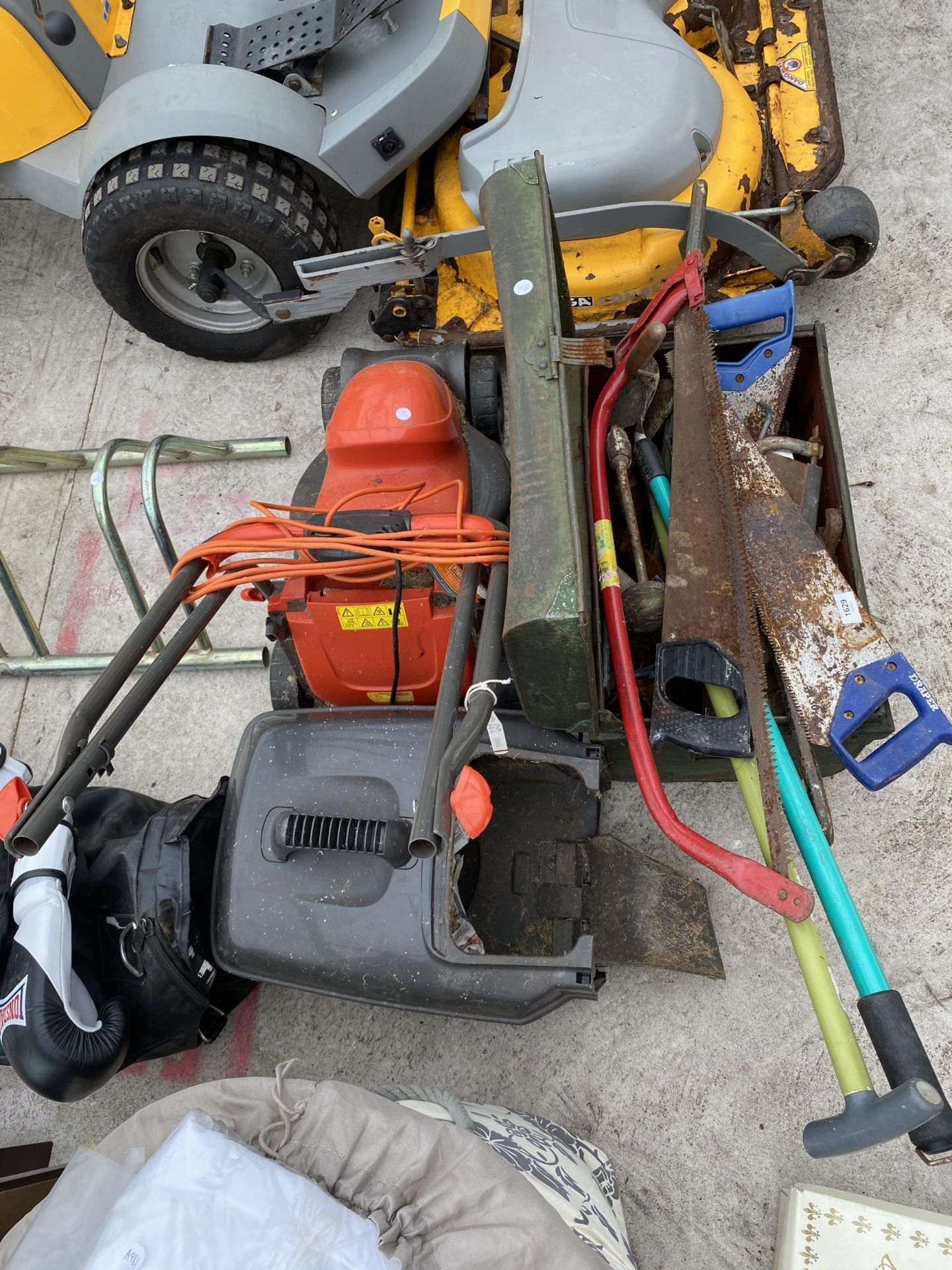 AN ASSORTMENT OF TOOLS TO INCLUDE GARDEN SHEAERS, AN ELECTRIC FLYMO LAWN MOWER AND HAND SAWS ETC