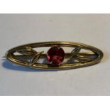 A 9 CARAT GOLD BROOCH WITH CENTRE RED STONE GROSS WEIGHT 2.64 GRAMS IN A PRESENTATION BOX
