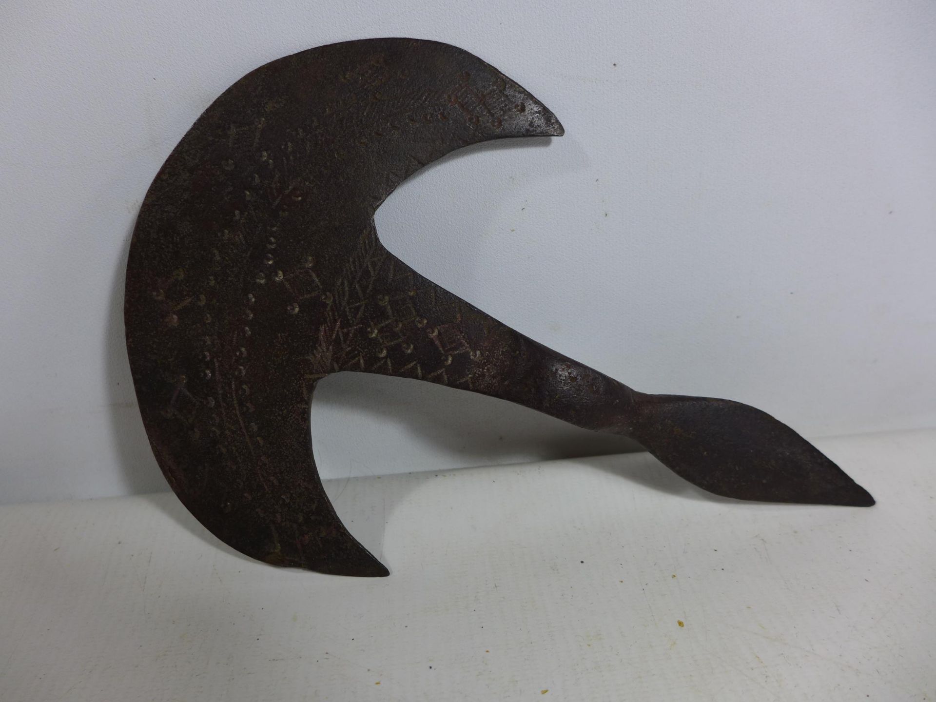 AN AXE HEAD WITH INCISED DECORATION, POSSIBLY AFRICAN, HEIGHT 15.5CM, LENGTH 23.5CM