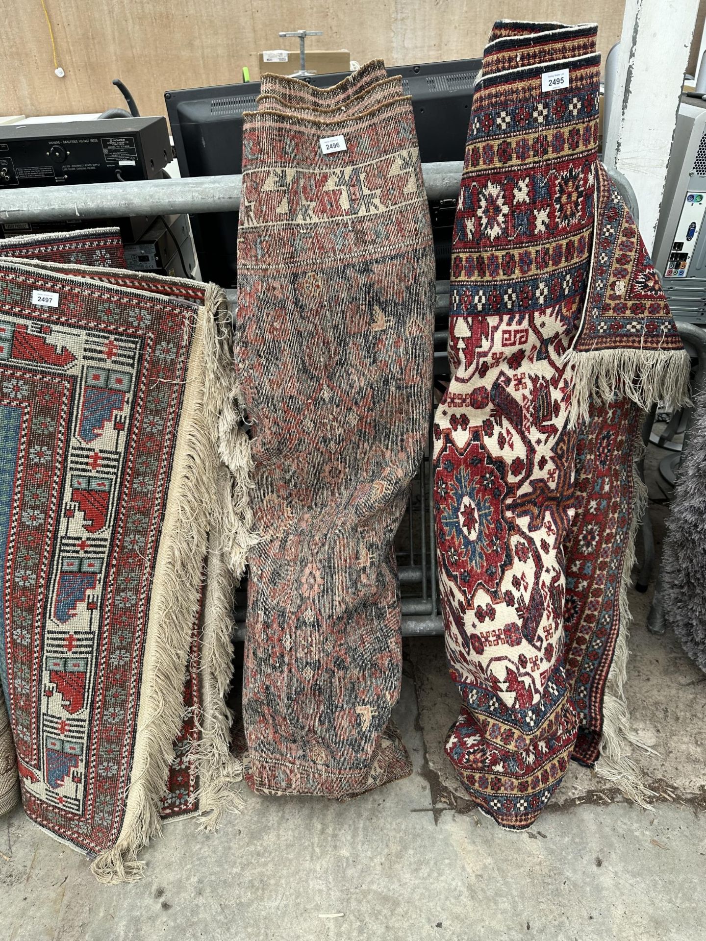 A VINTAGE RED PATTERNED FRINGED RUG