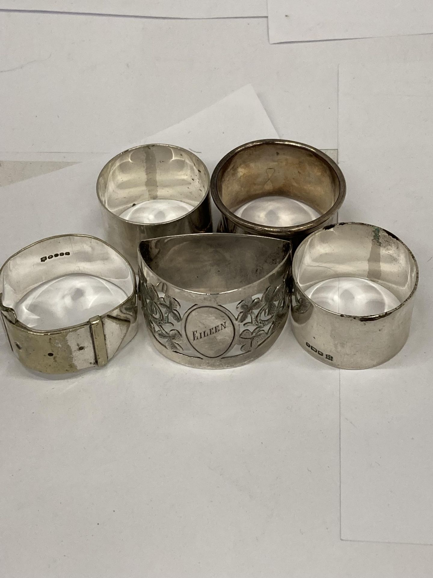 A COLLECTION OF FIVE HALLMARKED SILVER NAPKIN RINGS TO INCLUDE BUCKLE DESIGN EXAMPLE ETC