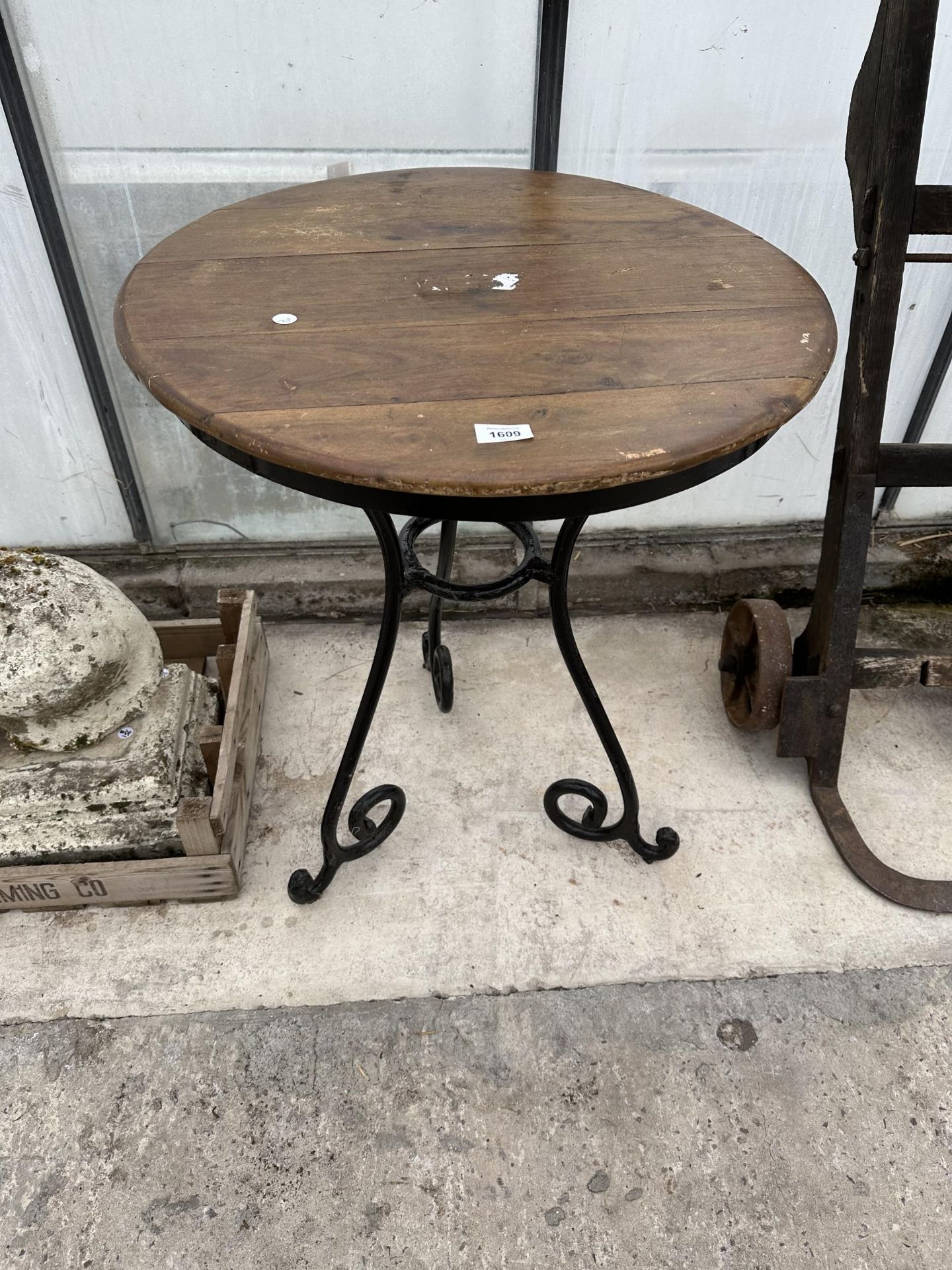 A WOODEN TOPPED BISTRO TABLE WITH HEAVY METAL LEGS