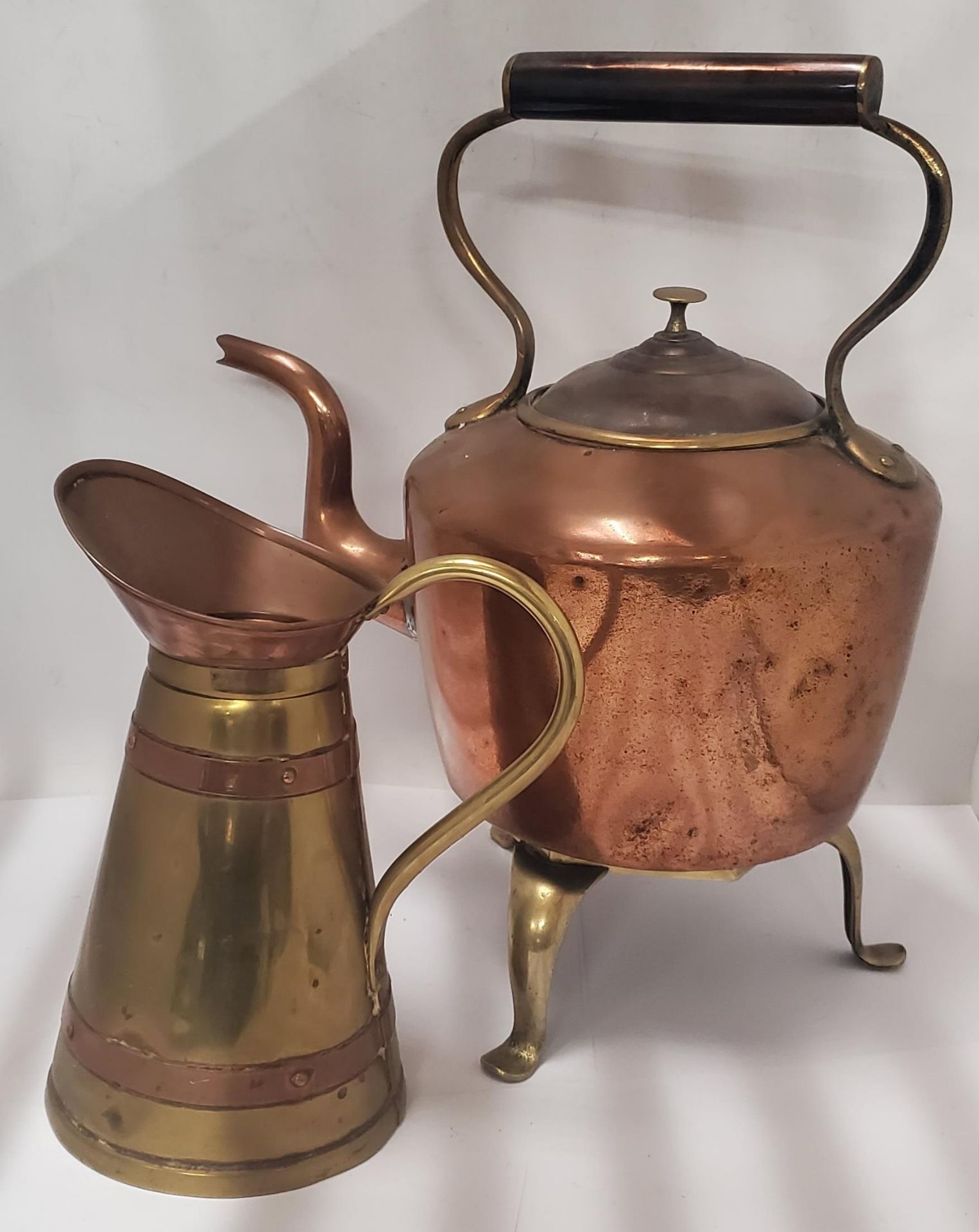 A VINTAGE COPPER KETTLE ON BRASS TRIPOD STAND AND FURTHER COPPER AND BRASS JUG