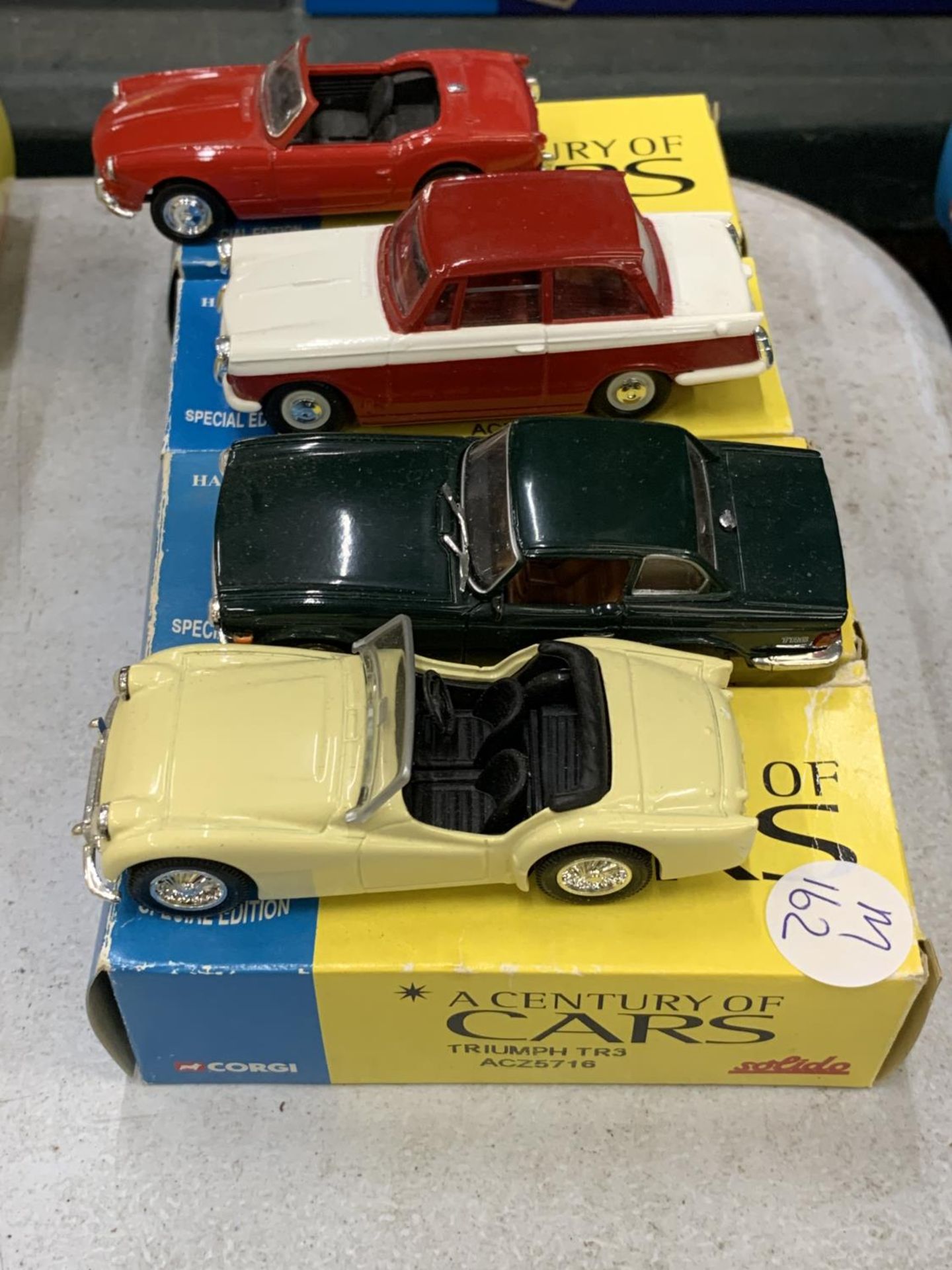 FOUR BOXED CORGI 'A CENTURY OF CARS' TO INCLUDE A TRIUMPH SPITFIRE, HERALD, TR6 AND A TR3