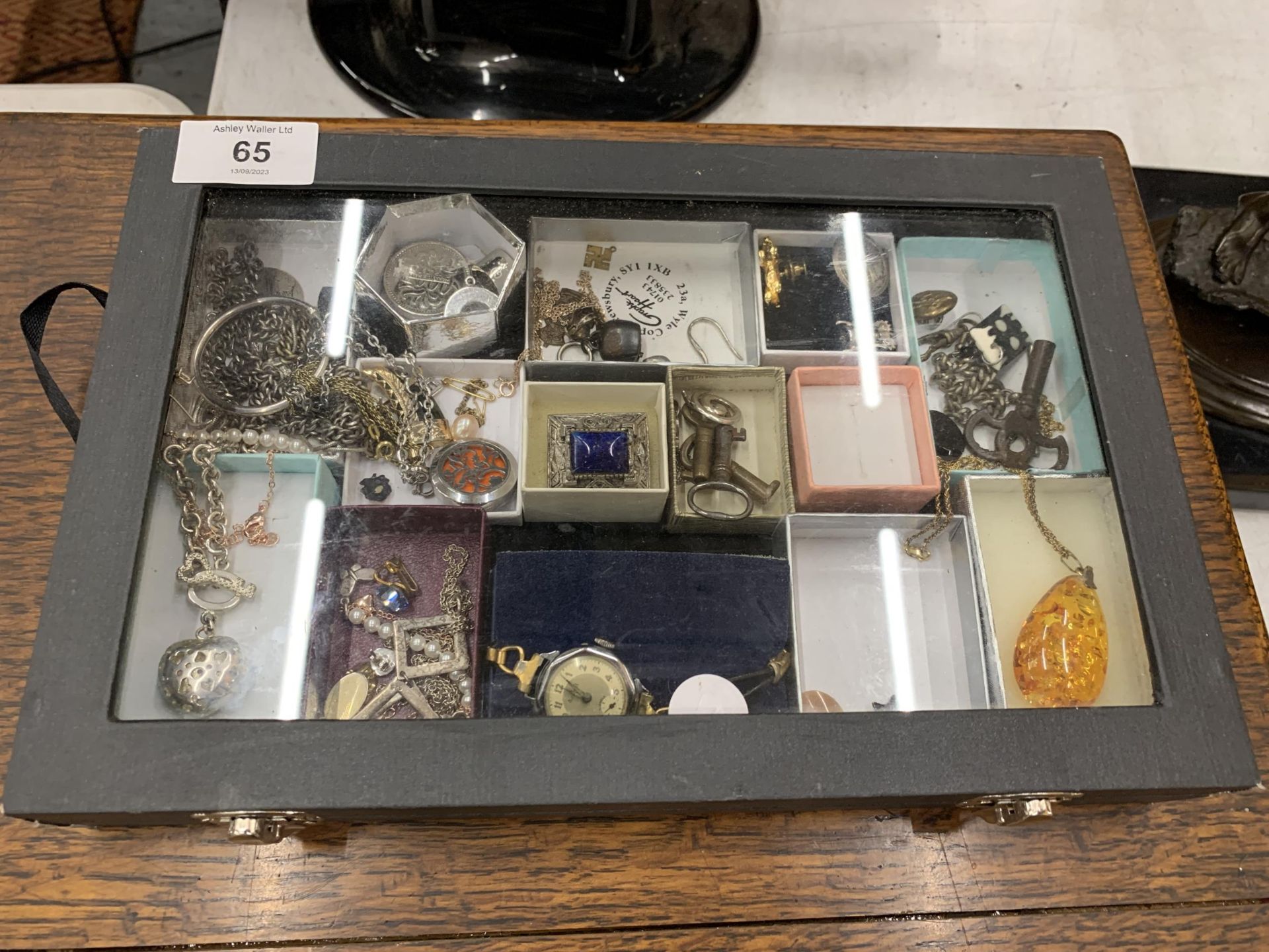 A GLASS TOPPED JEWELLERY DISPLAY BOX WITH CONTENTS