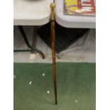 A YELLOW METAL HANDLED WALKING STICK