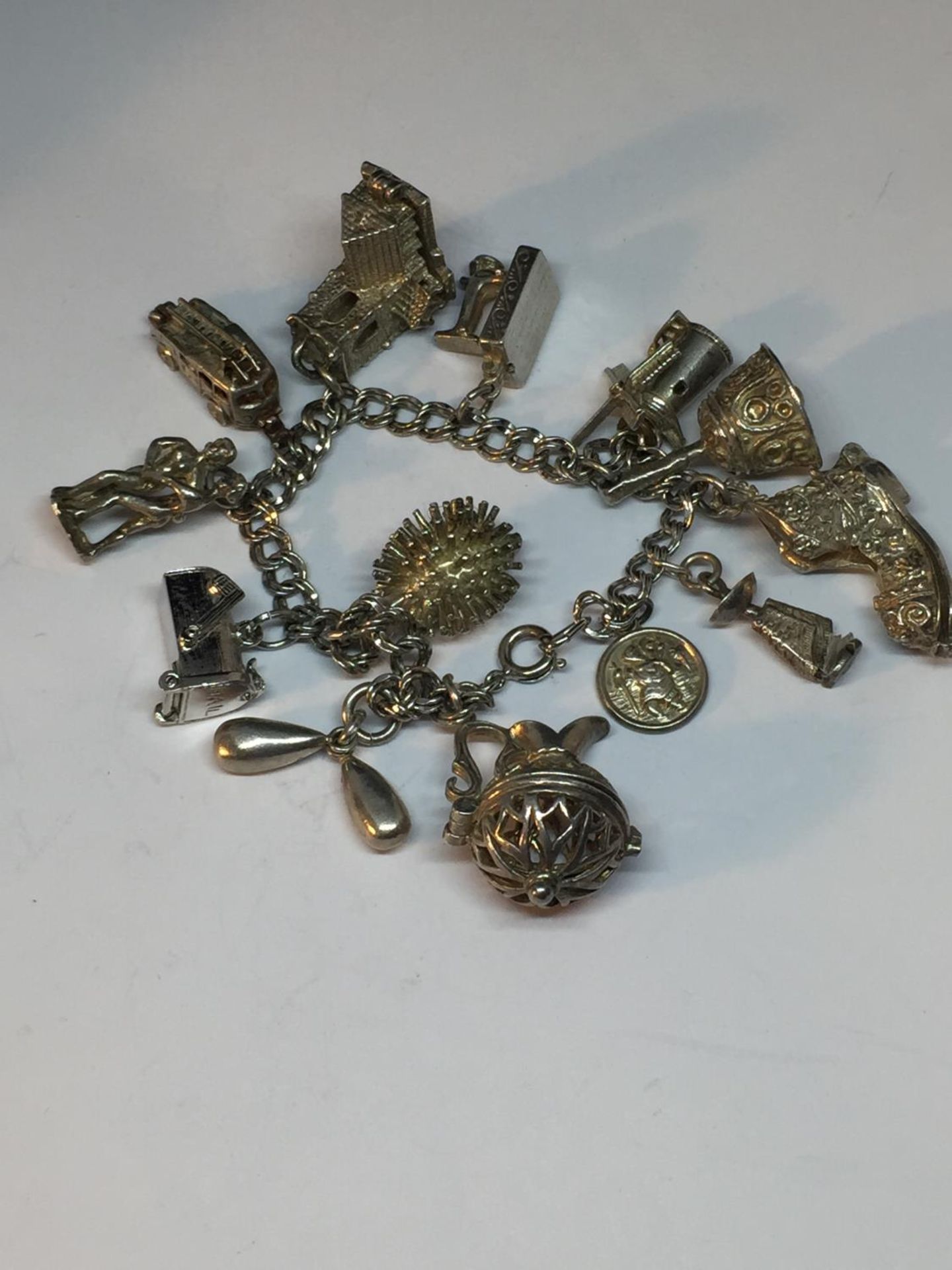 A SILVER CHARM BRACELET WITH 13 CHARMS