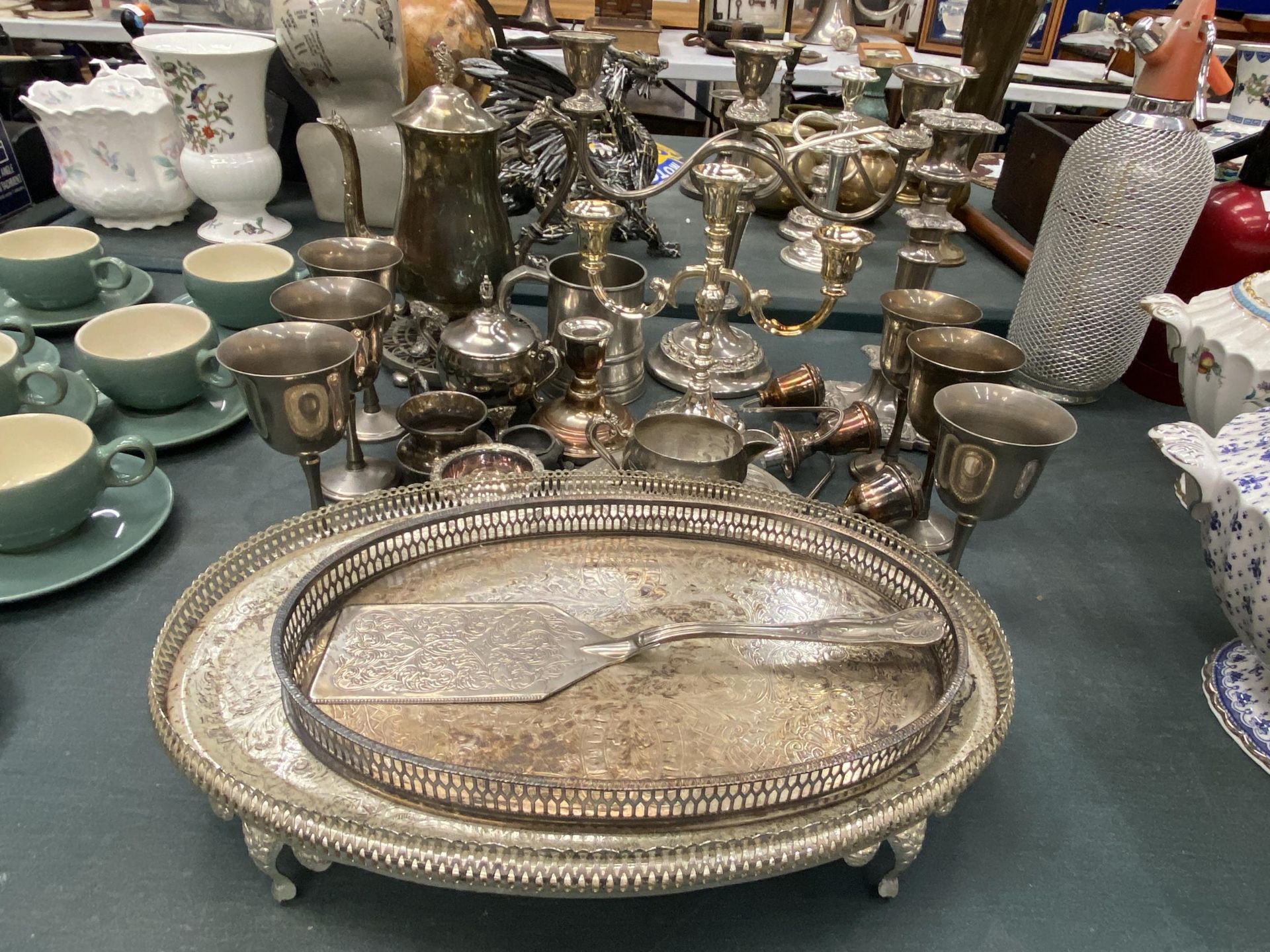 A LARGE QUANTITY OF VINTAGE SILVER PLATED ITEMS TO INCLUDE GALLERIED TRAYS, GOBLETS, CANDLEABRAS,