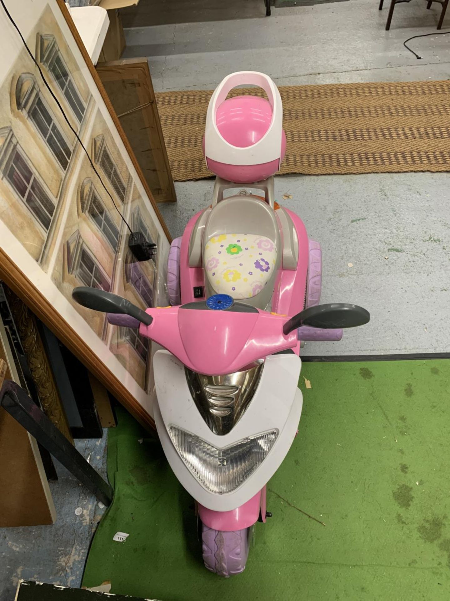 A CHILDREN'S PINK ELECTRIC THREE WHEELED SCOOTER WITH CHARGER - VENDOR STATES IN WORKING ORDER AND