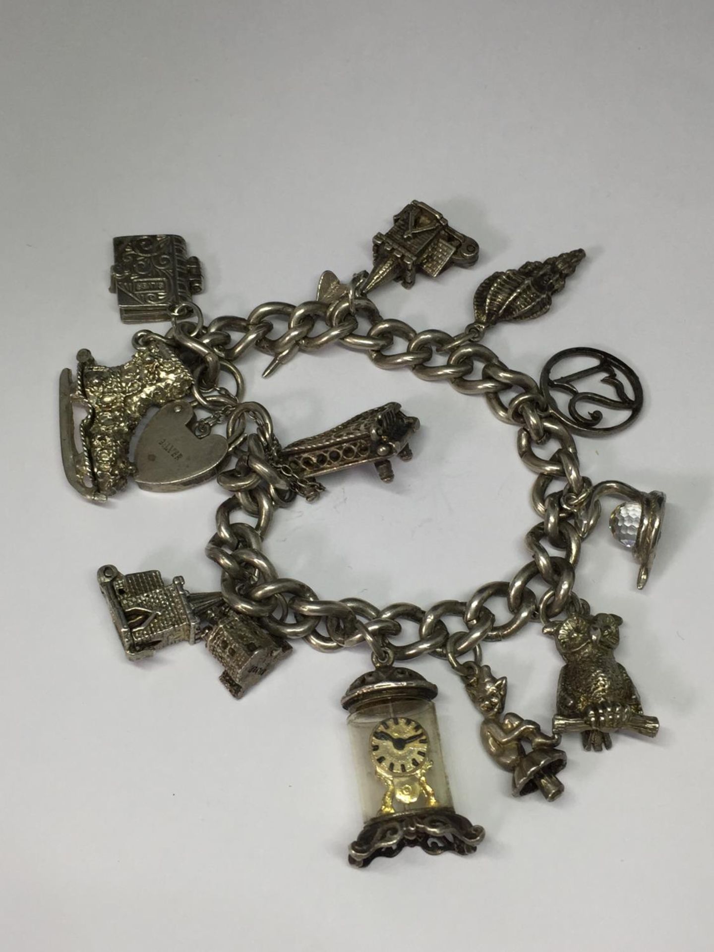 A SILVER CHARM BRACELET WITH THIRTEEN VARIOUS CHARMS