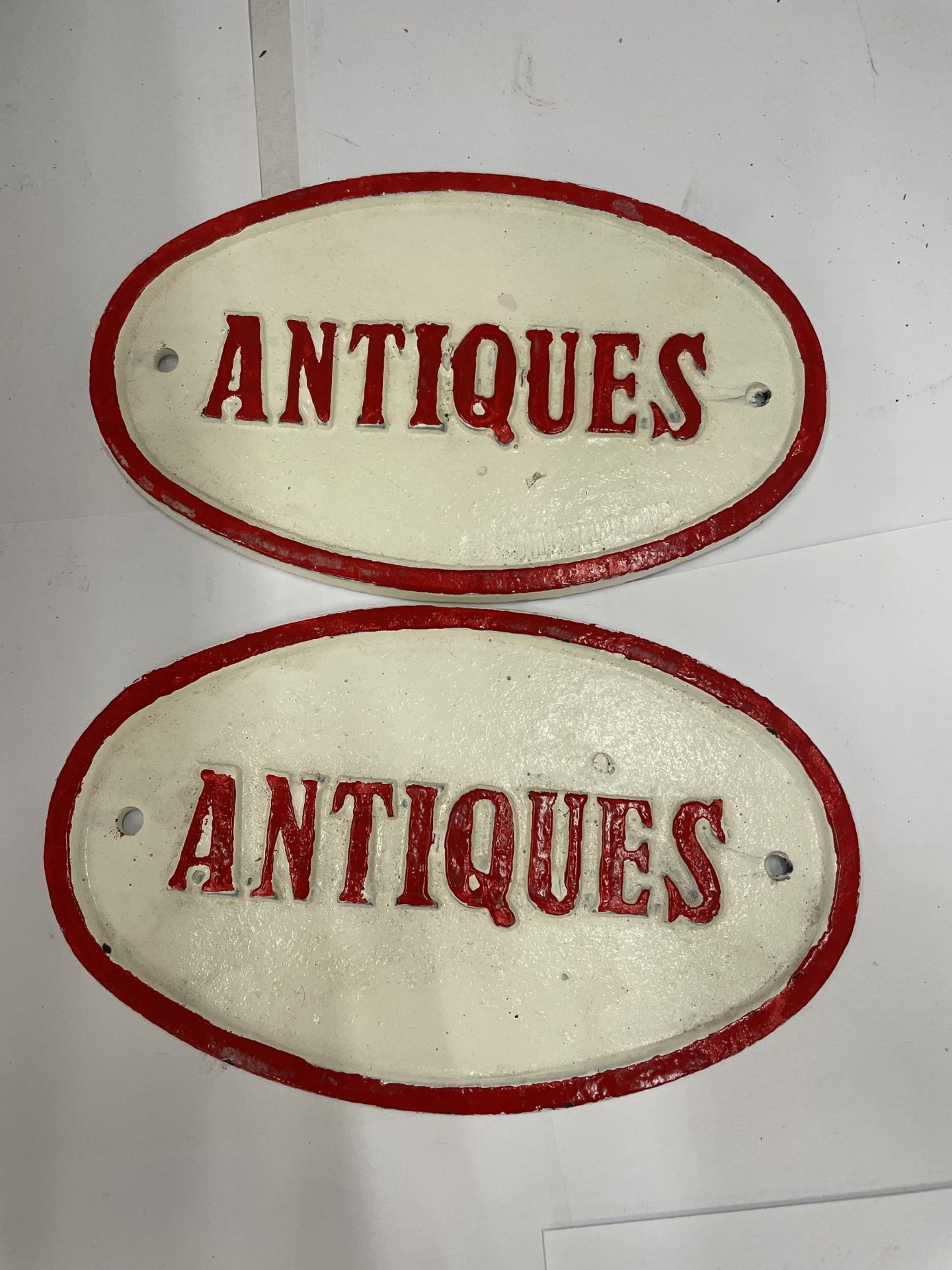 A PAIR OF CAST ANTIQUES OVAL SIGNS