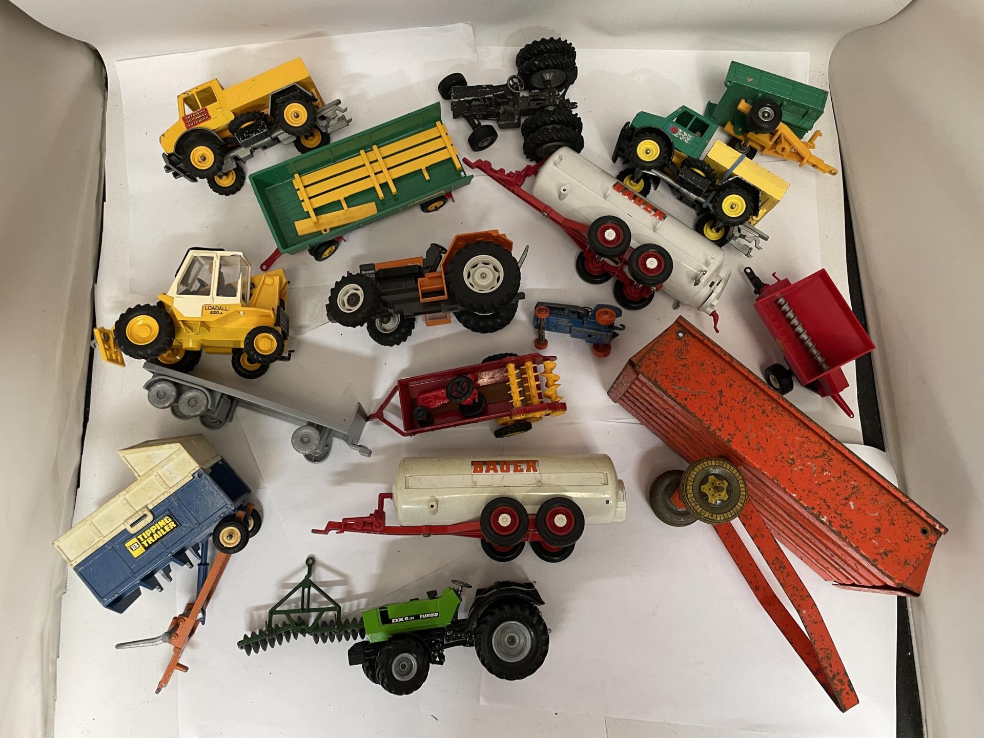 A COLLECTION OF BRITAINS FARM VEHICLES TO INCLUDE TRACTORS, TRAILERS, MACHINES, ETC