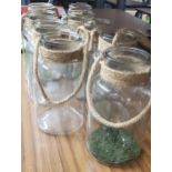 A GROUP OF NINE GLASS JARS WITH ROPE HANGING DESIGN