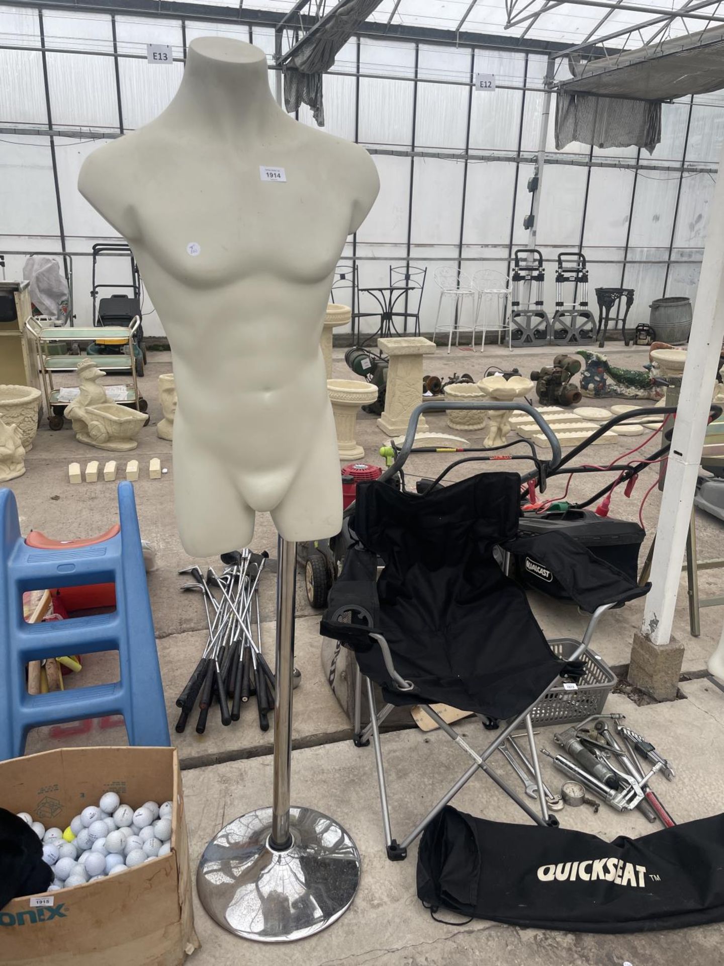 A MALE TORSO MANNEQUIN ON A CHROME STAND