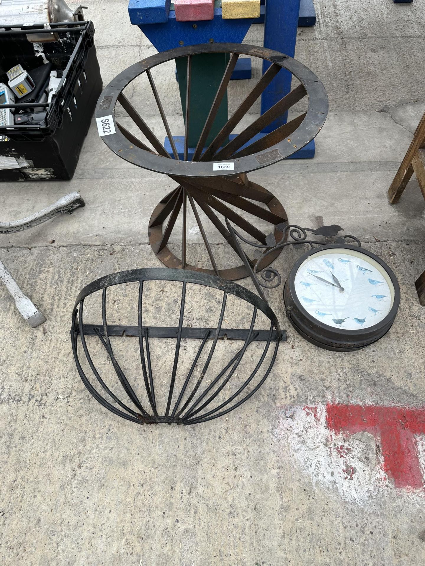 AN OUTDOOR CLOCK, A HAYRACK PLANTER AND A FURTHER METAL TABLE BASE