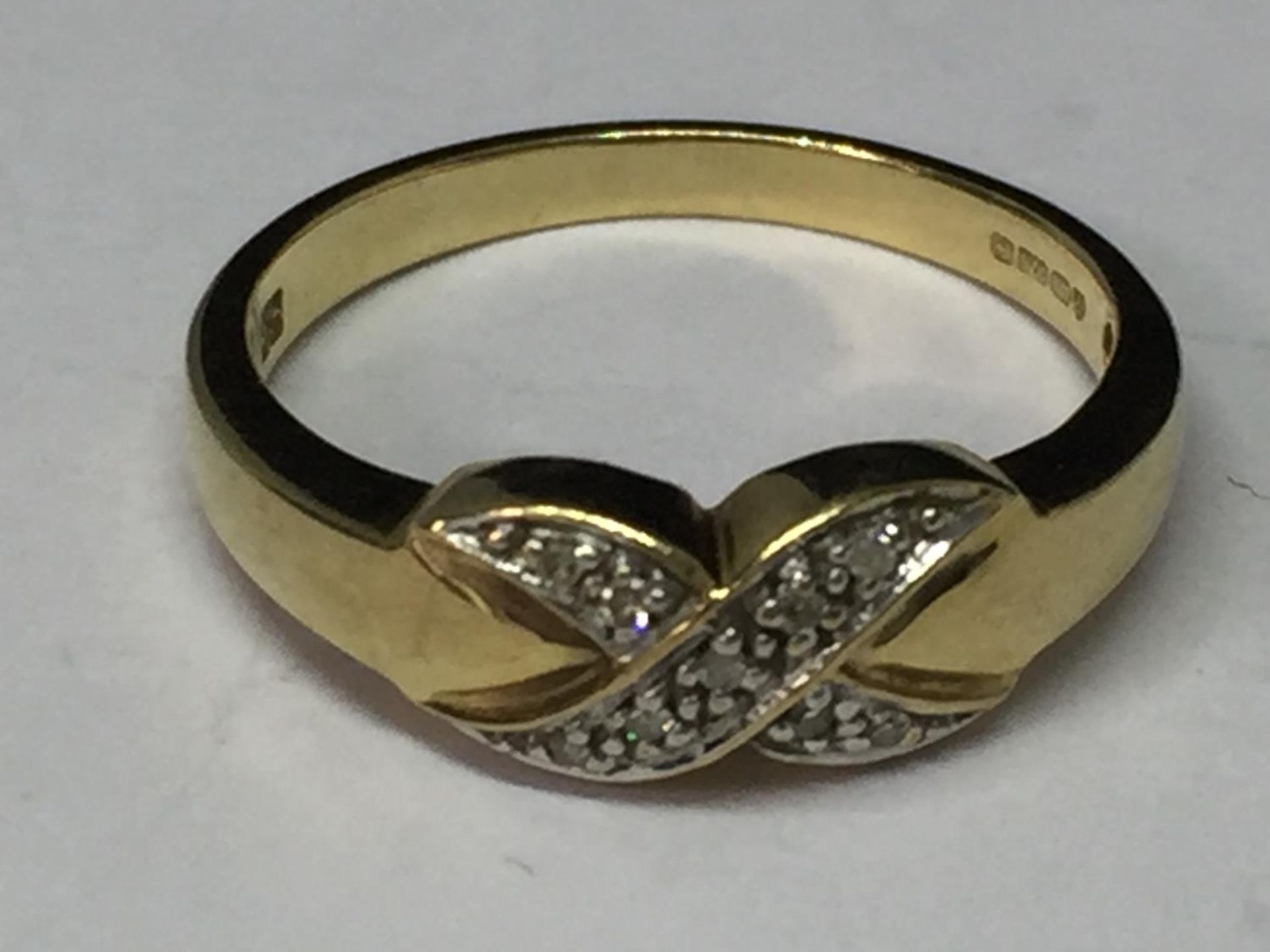 A 9 CARAT GOLD RING WITH DIAMONDS IN A CROSS DESIGN SIZE M/N