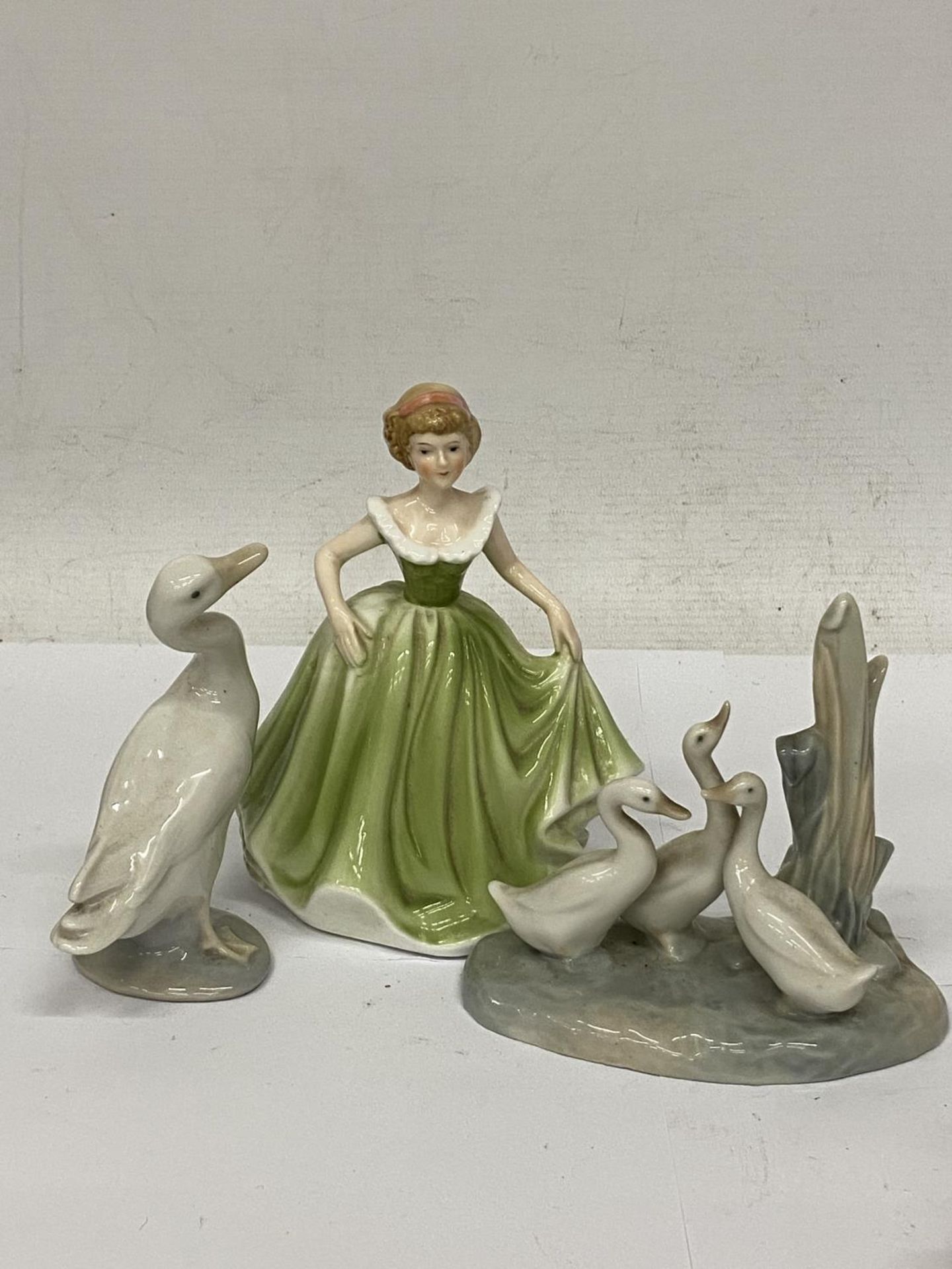 A SHUDEHILL FIGURE OF A LADY IN A GREEN DRESS TOGETHER WITH A LLADRO FIGURE OF A DUCK AND A NAO