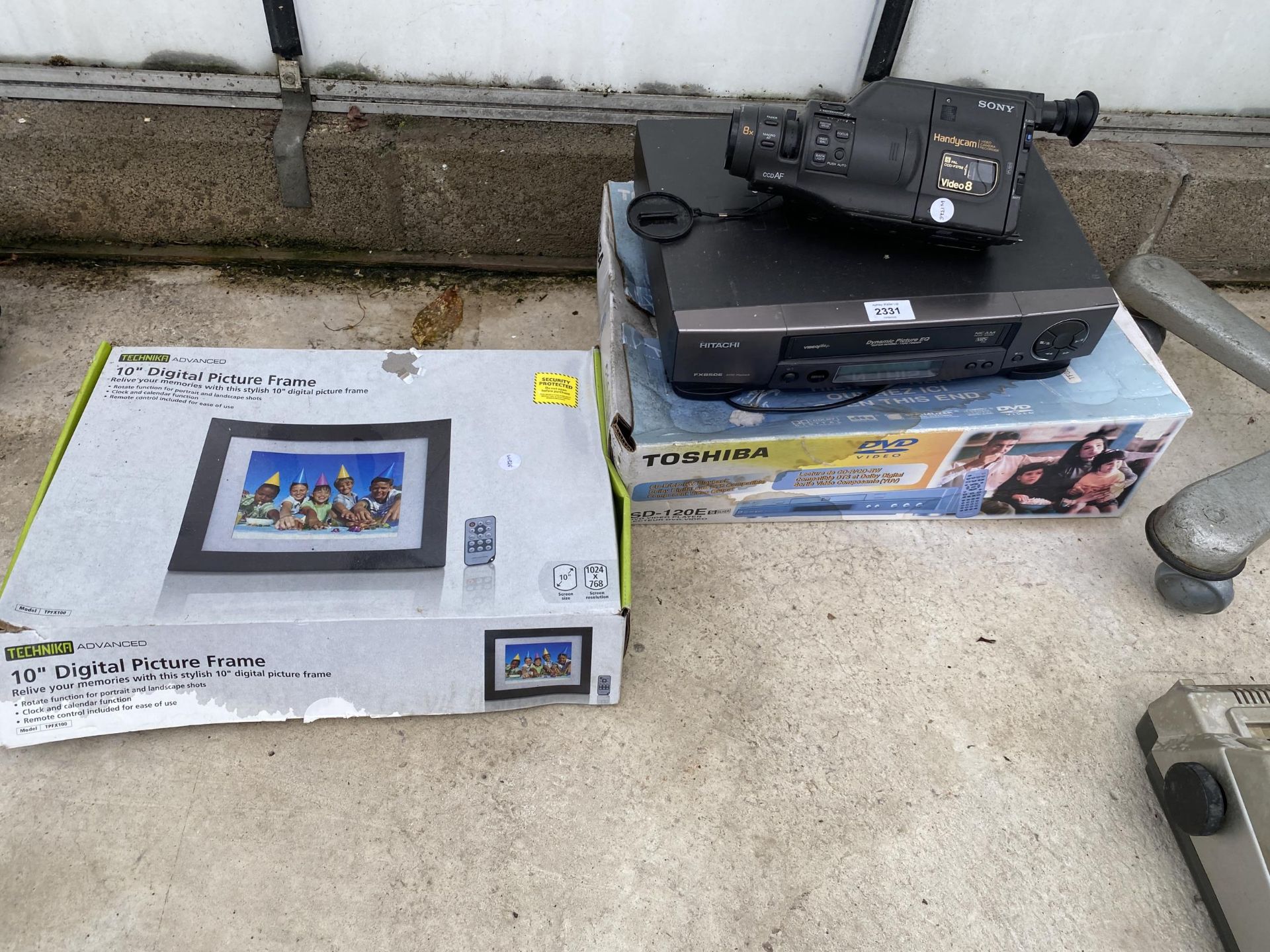 AN ASSORTMENT OF ITEMS TO INCLUDE A CAMCORDER, A VHS PLAYER AND A PICTURE FRAME